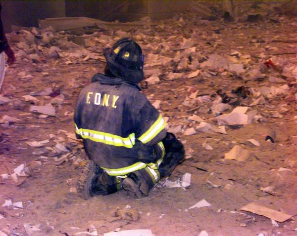 A firefighter praying at ground zero.   